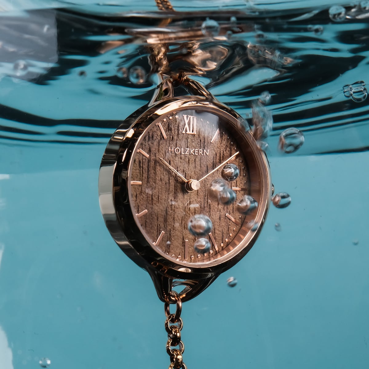 "Blissed" watch features a walnut face and rose gold accents, captured elegantly underwater.