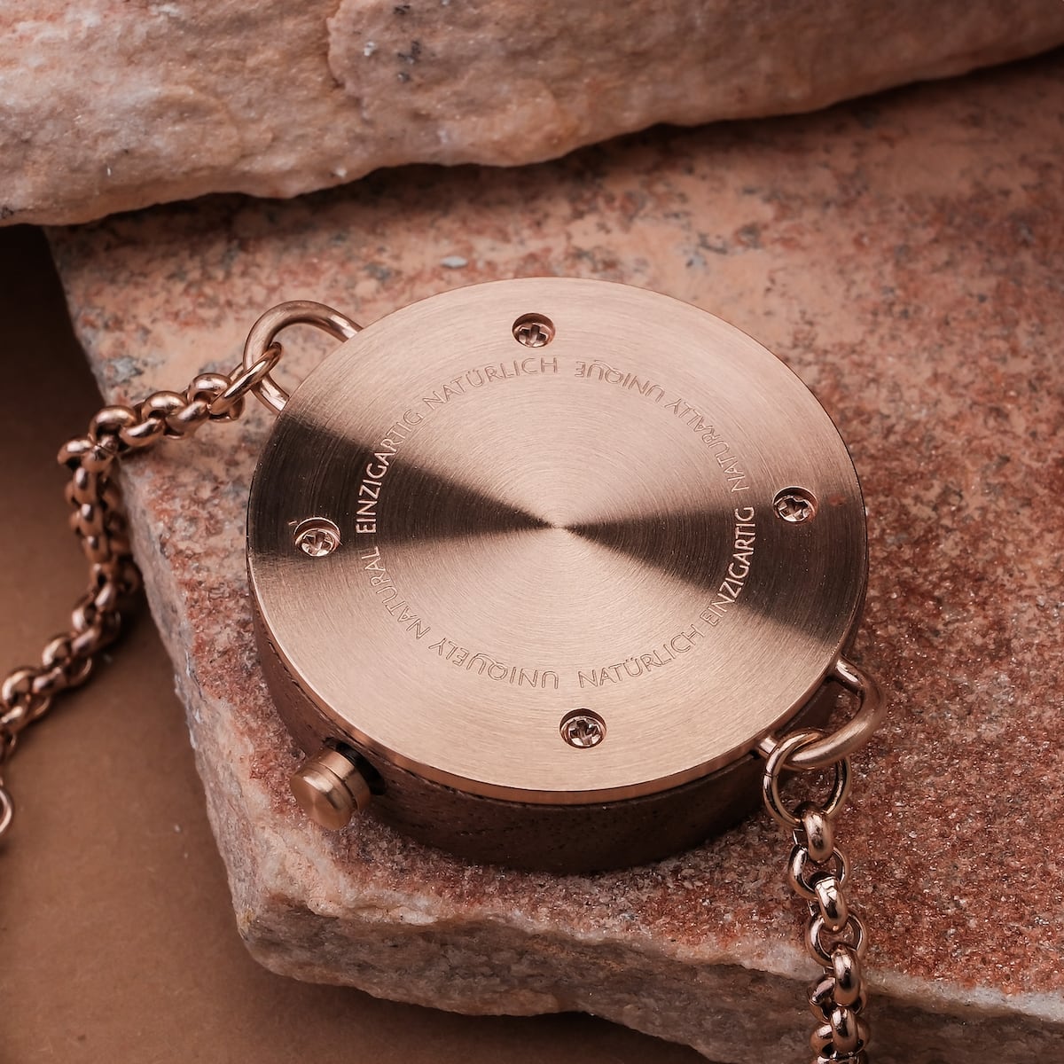 "Leave", a styled circular accessory in a sophisticated walnut finish, featuring intricate metal chain details.