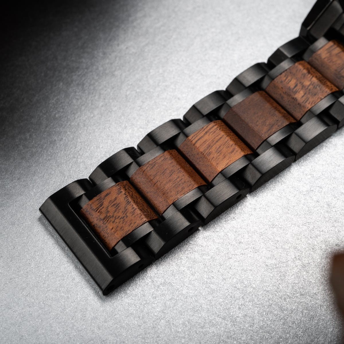 "Scattered" watch band featuring a marble and koa wood inlay with a sleek, modern design.