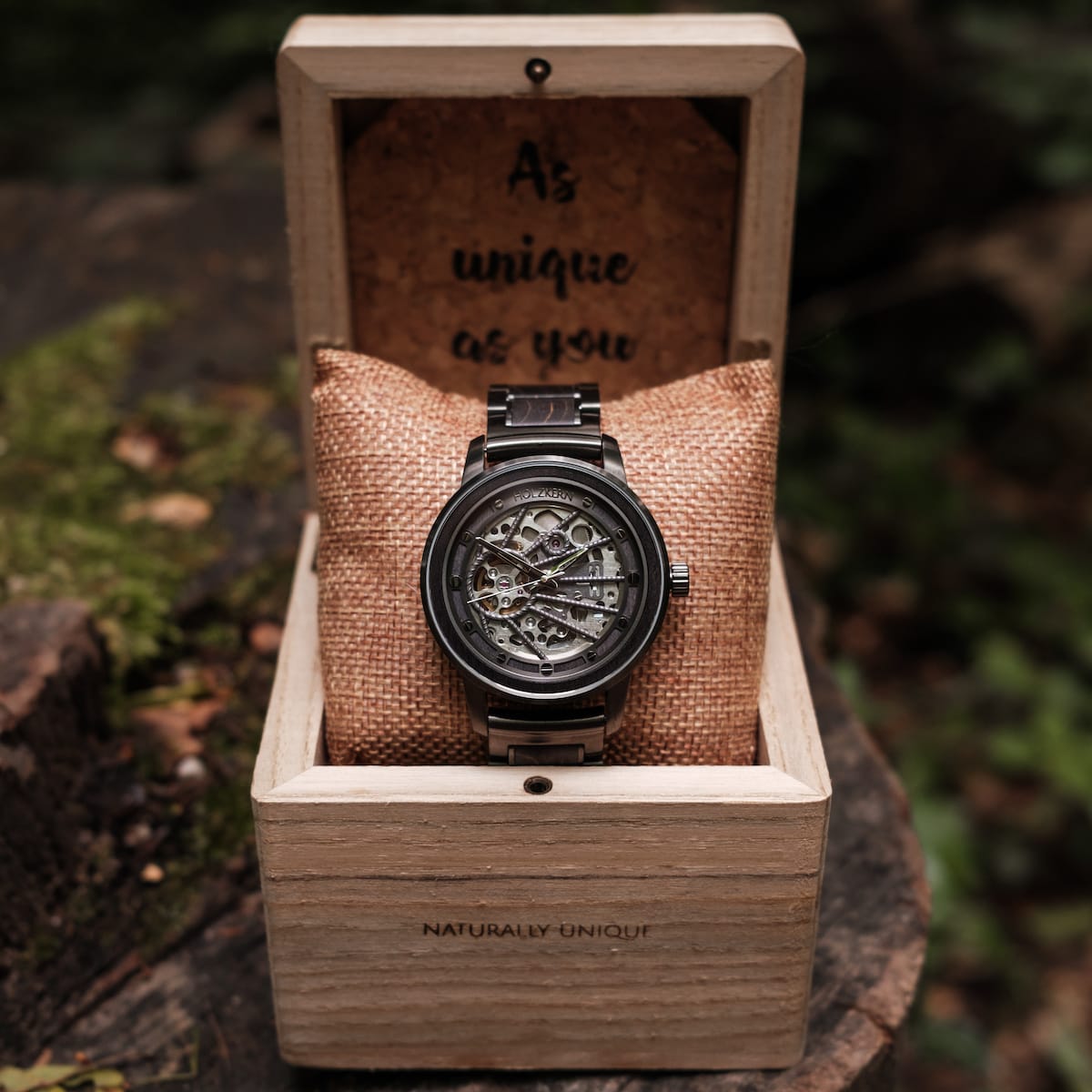 "Carbon" watch featuring a skeleton dial with gray maple and dark gray accents in a rustic wood box.