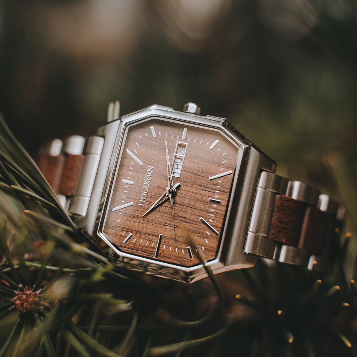 "Gaudí" watch with a walnut face and stainless steel accents, featuring a modern, elegant design.