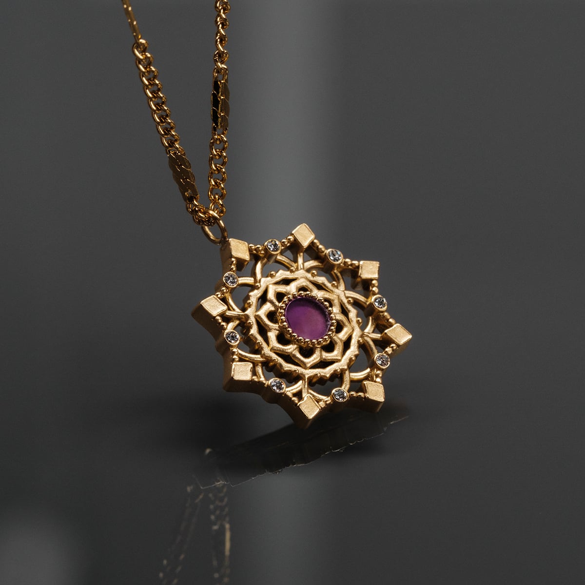 "Aphonia Necklace" necklace featuring an ornate gold design with an amethyst center, exuding elegance and sophistication.