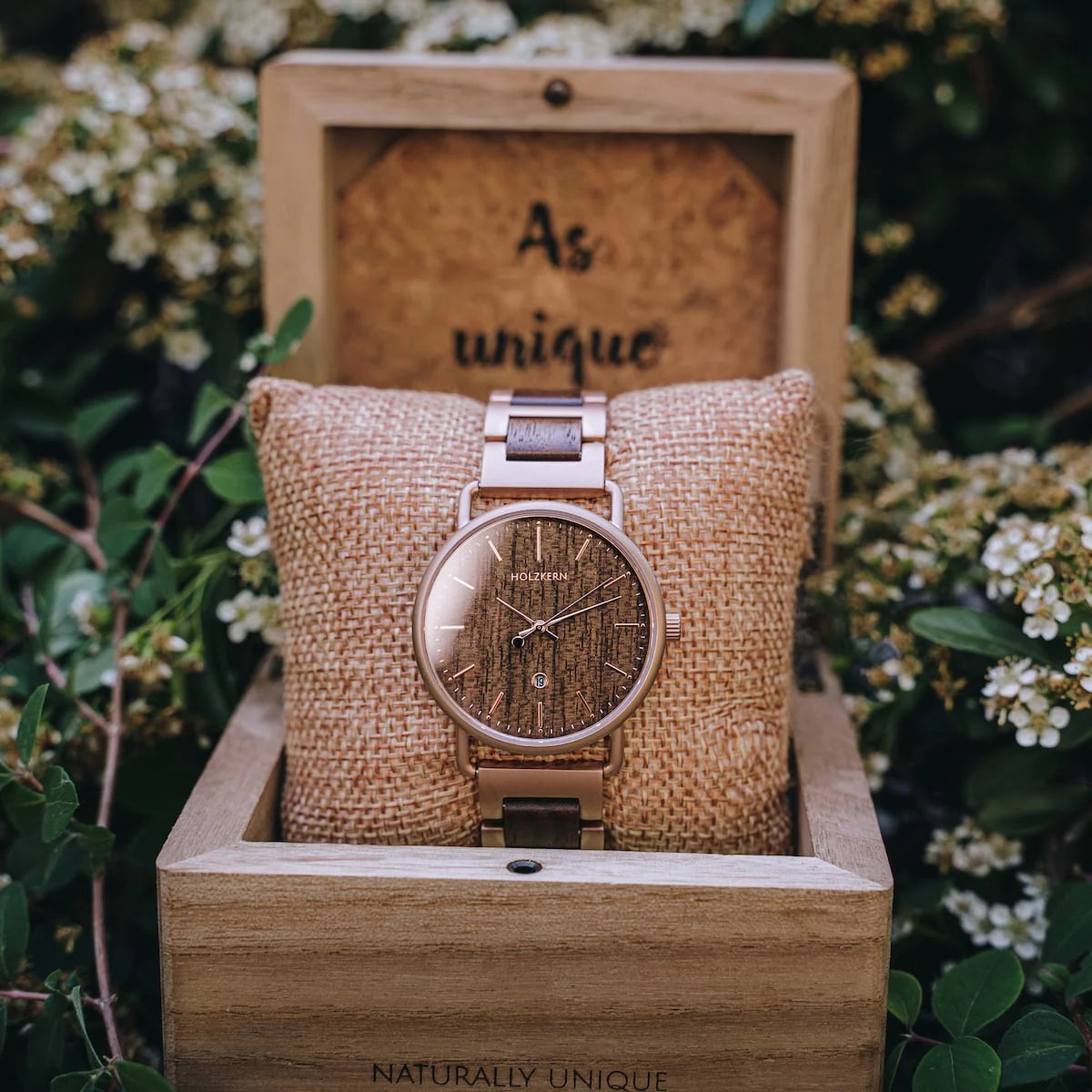 "Belvue" watch featuring a walnut case and strap, presented in a natural and elegant style against a floral backdrop.