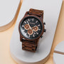 "Thicket", a stylish watch made from Walnut wood and marble, features a sleek design with a dark face and wooden bracelet.