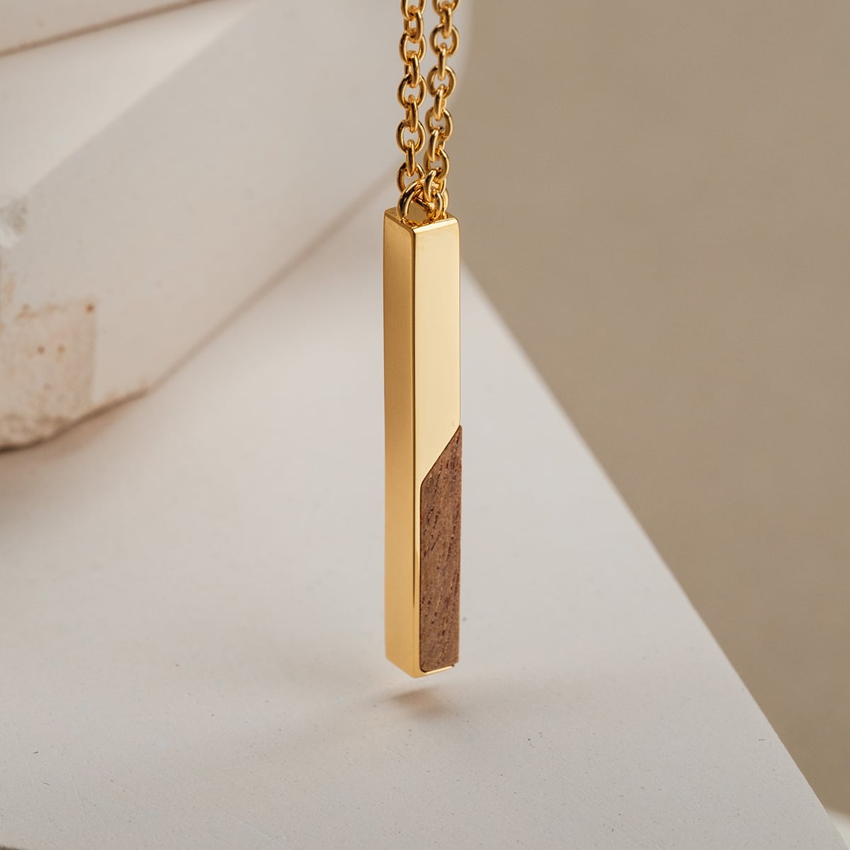 "Campania Necklace", a stylish gold necklace featuring a sleek rectangular pendant with koa wood accent.