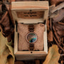 "The Optimist" watch featuring walnut wood and a peacock feather dial, displayed elegantly in a rustic wooden box.