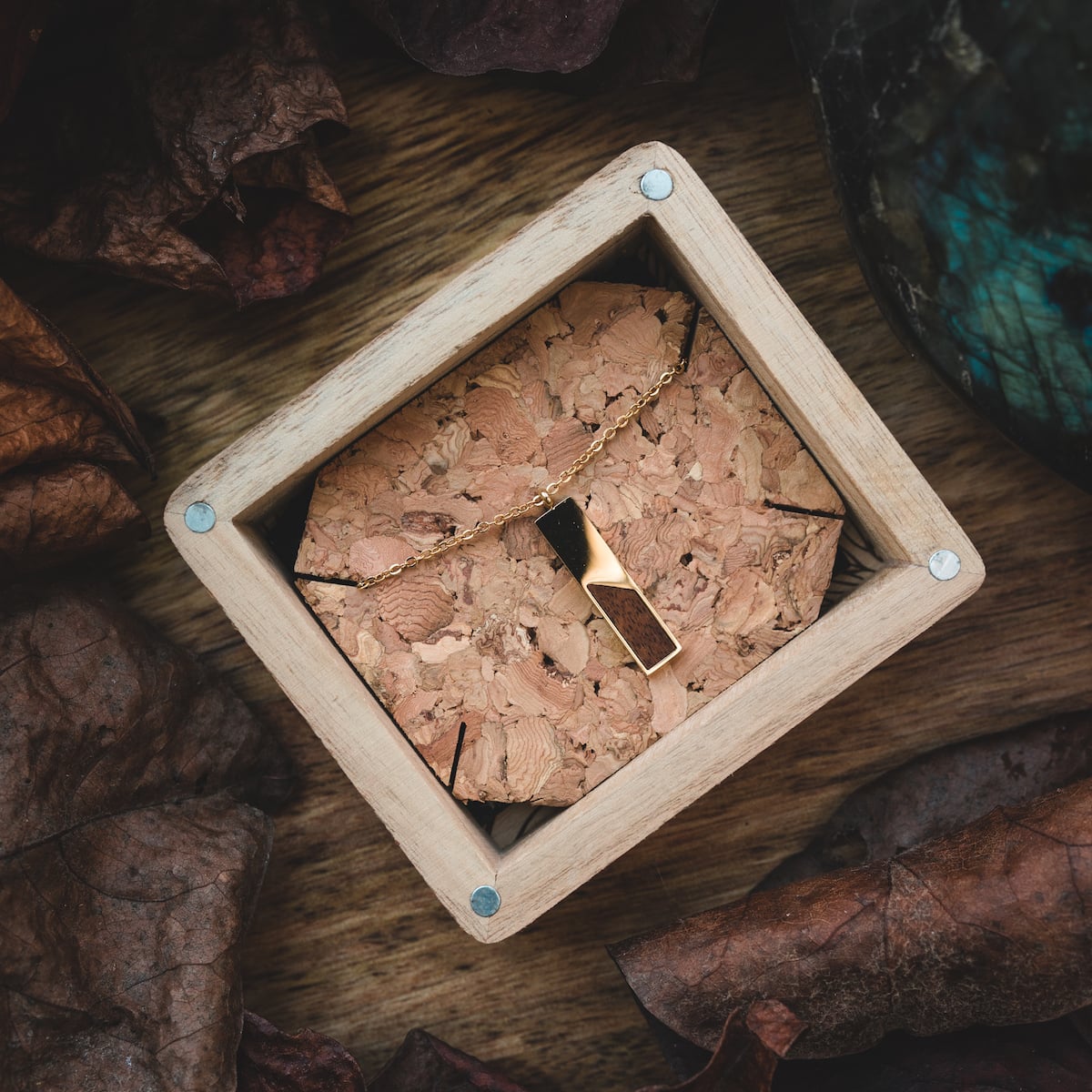 Ephemera Necklace: elegant necklace featuring koa wood and gold accents in a rustic display box.