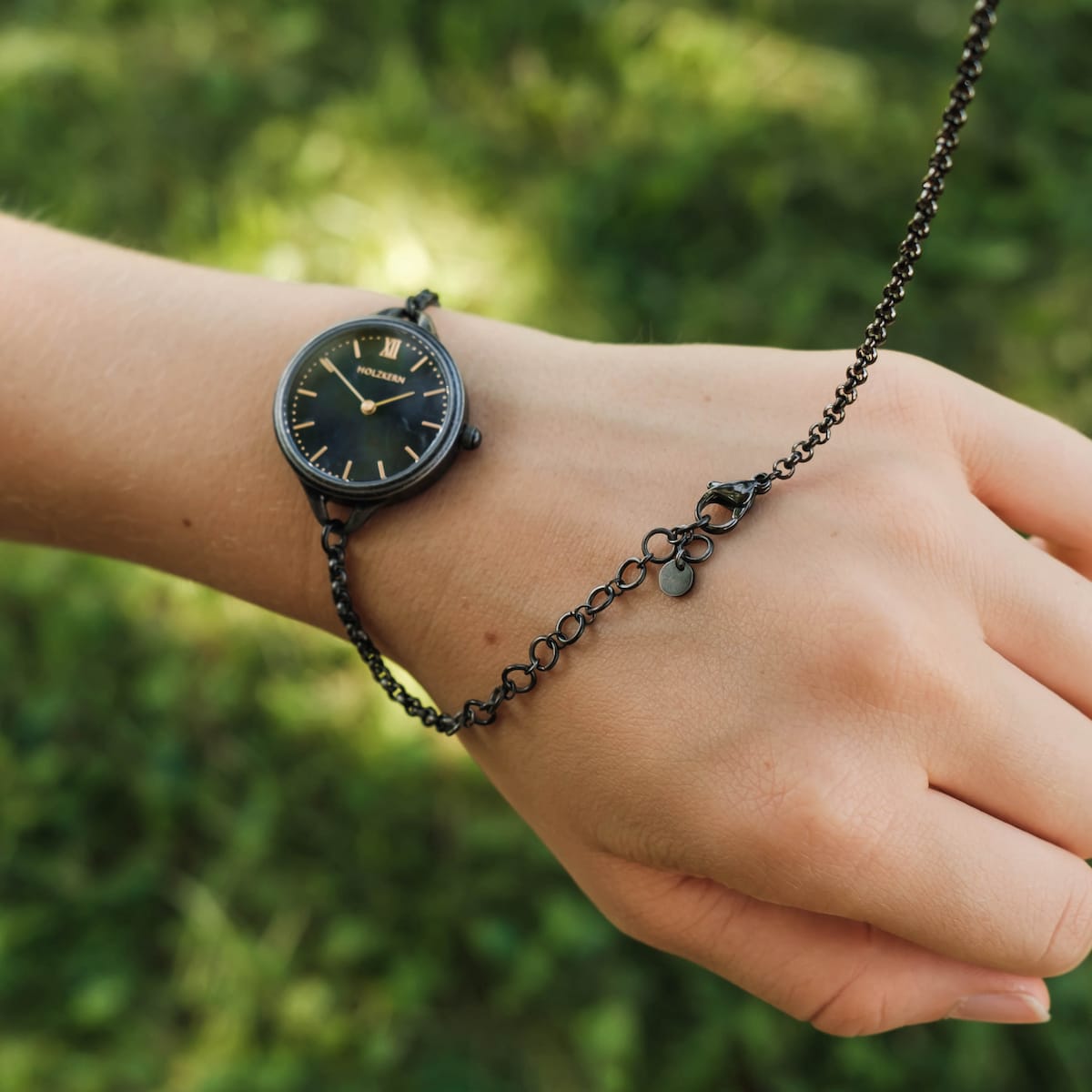 "Bracelet fastening tool", a sleek bracelet fastening tool, shown in grey with a minimalist style.