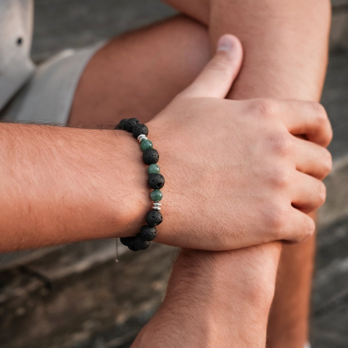 "Superset" bracelet with a mix of textured black lava and smooth marble beads, worn on wrist.