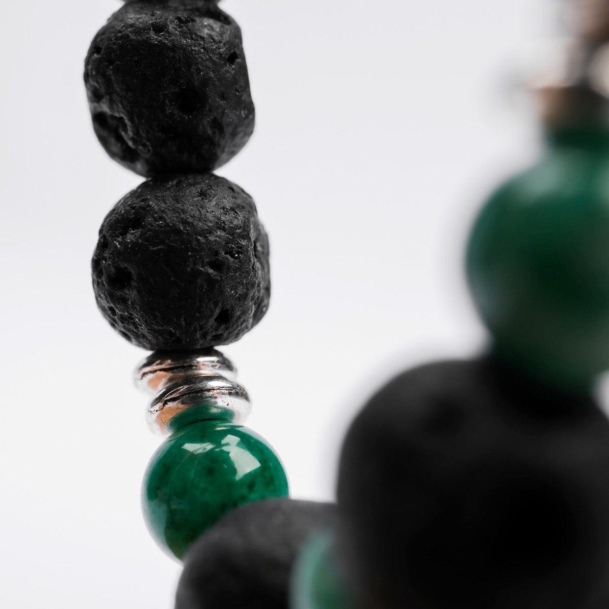 "Superset", a beaded accessory, features a bold design with contrasting dark lava and green marble elements.