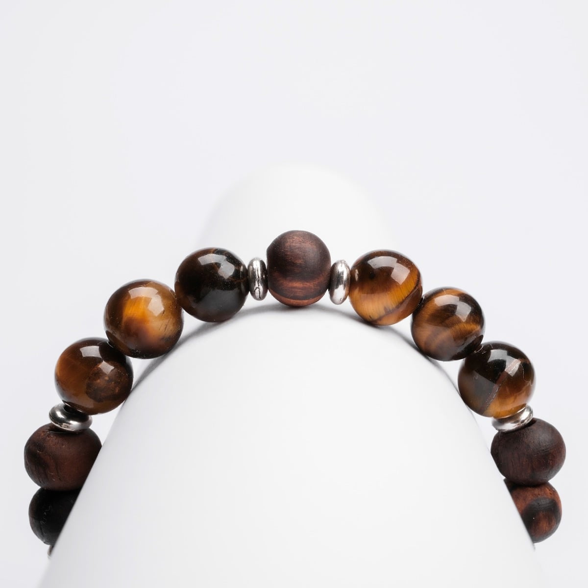 "Superset", a bracelet with tiger eye and walnut beads, features a sleek, earthy aesthetic.