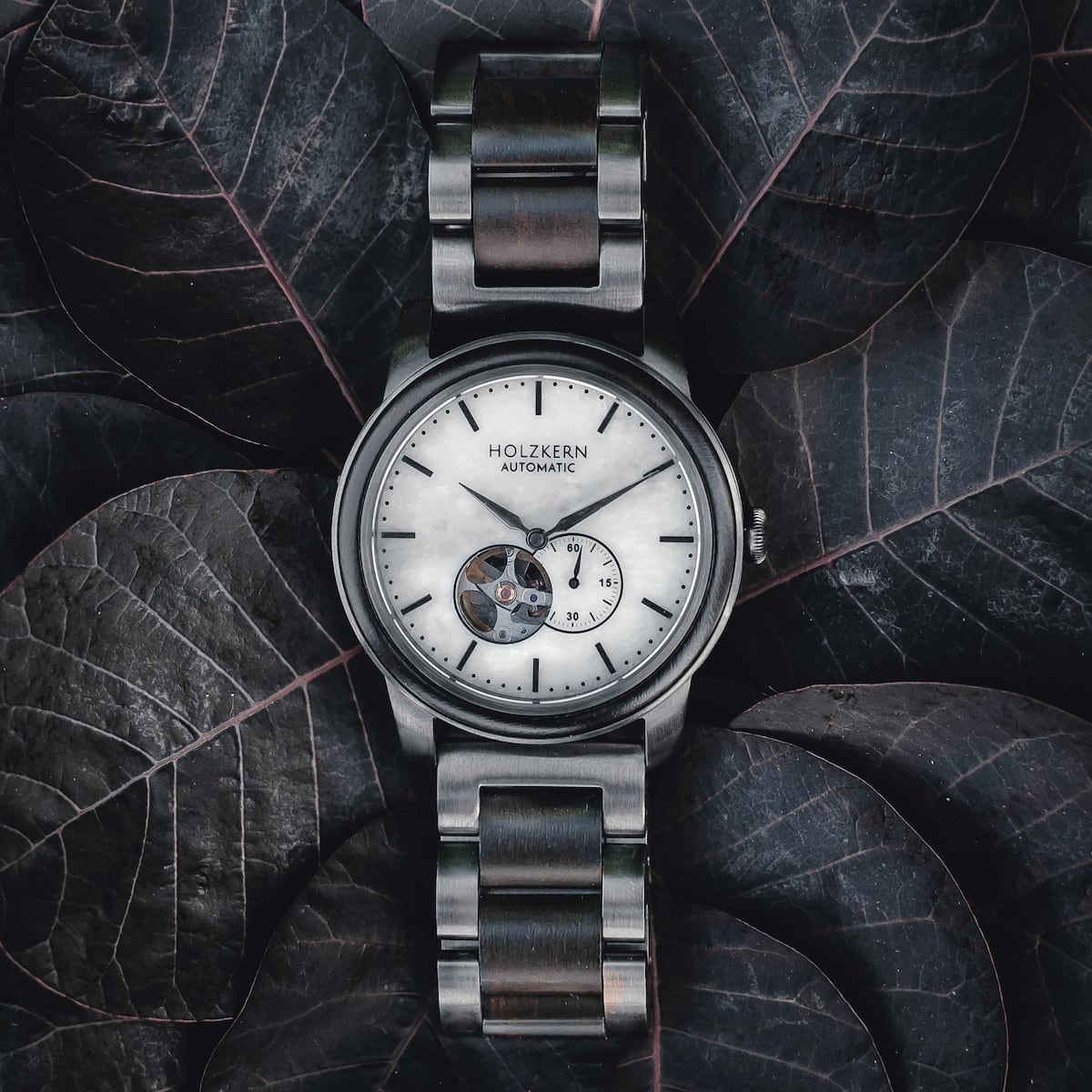 "Manhattan" watch with a maple and marble design, featuring a sleek, modern aesthetic against a dark leaf backdrop.