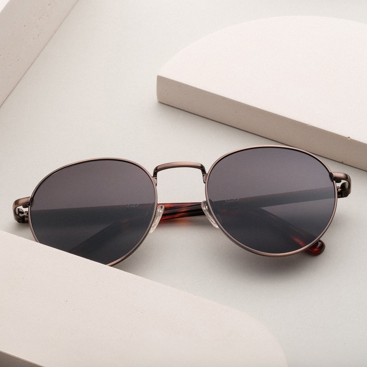 "The Achiever" sunglasses, featuring a walnut and copper design, showcasing a sleek, modern style.
