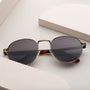 "The Achiever" sunglasses, featuring a walnut and copper design, showcasing a sleek, modern style.