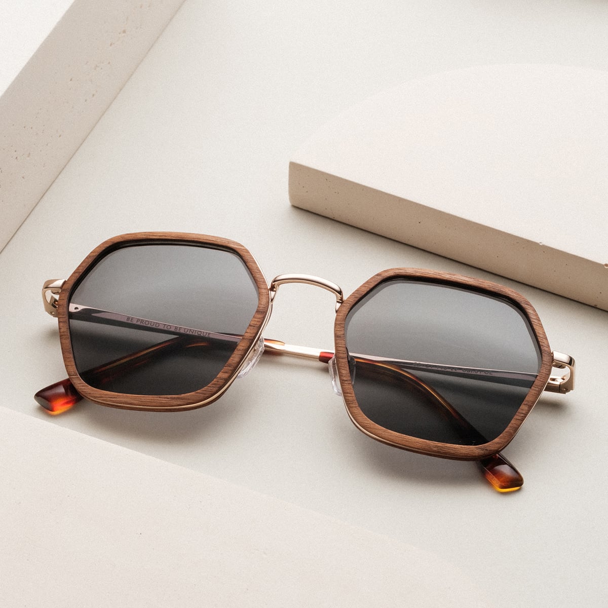 "The Sincere" sunglasses feature a walnut and matte gold geometric frame for a stylish look.