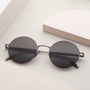 "The Adventurous" sunglasses with walnut accents and dark gray lenses, featuring a sleek, modern design.