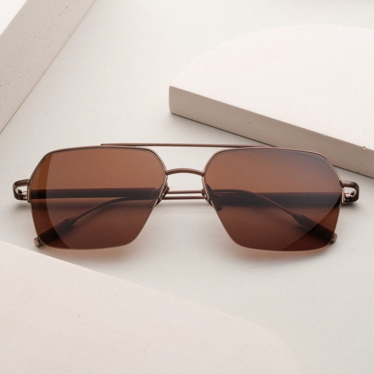 "The Visionary", walnut and bronze sunglasses with a sleek, modern design.