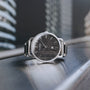 "Odaiba" elegantly wristwatch featuring a maple dial and sleek design, set against an urban backdrop.