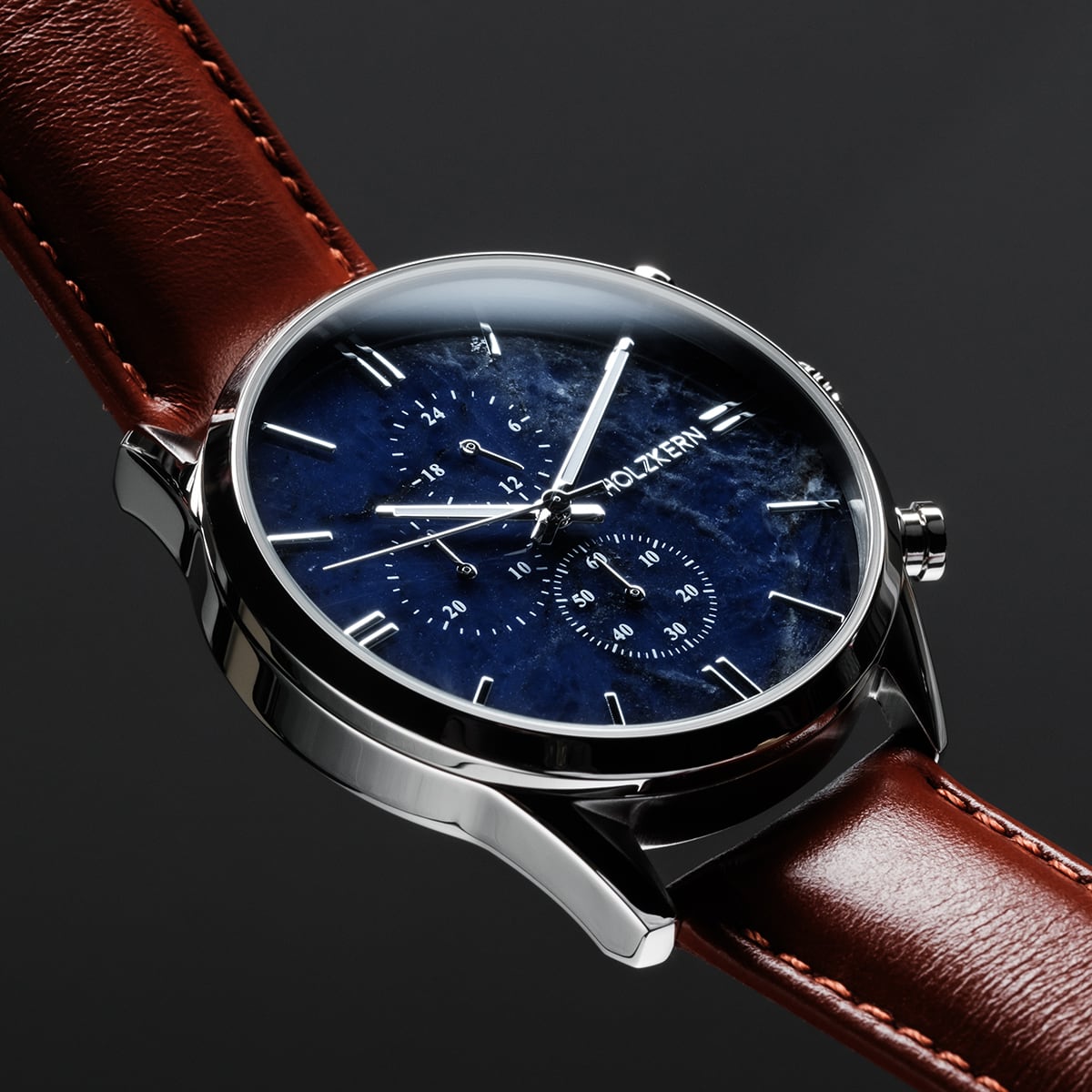 "Naturalist", a stylish watch with a marble dial and silver accents, featuring a sleek brown leather strap.