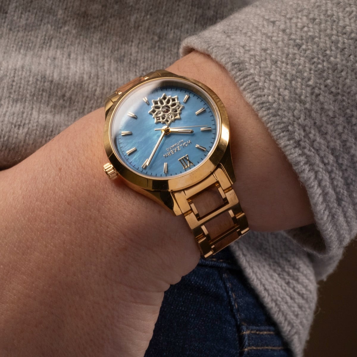 "Kaleidoscopic" watch featuring a nacre dial and olive accents, showcasing a refined and elegant style.
