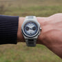 "Oceanswell", a ceramic and silver wristwatch with a sleek, modern design.