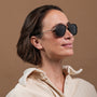 "The Logician" sunglasses featuring Leadwood/Antique Silver frame, worn by a woman with a neutral expression.