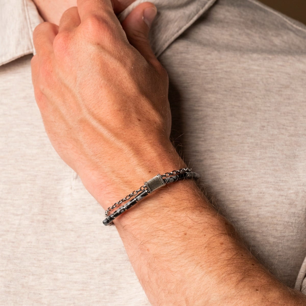 "Supersonic", a stylish bracelet featuring a blend of obsidian and silver tones, elegantly worn on a wrist.