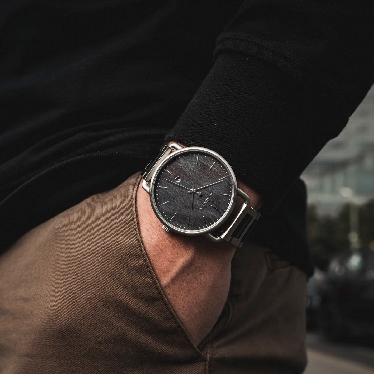 "Odaiba" watch with a sleek black dial and silver casing, worn with casual attire for a modern look.
