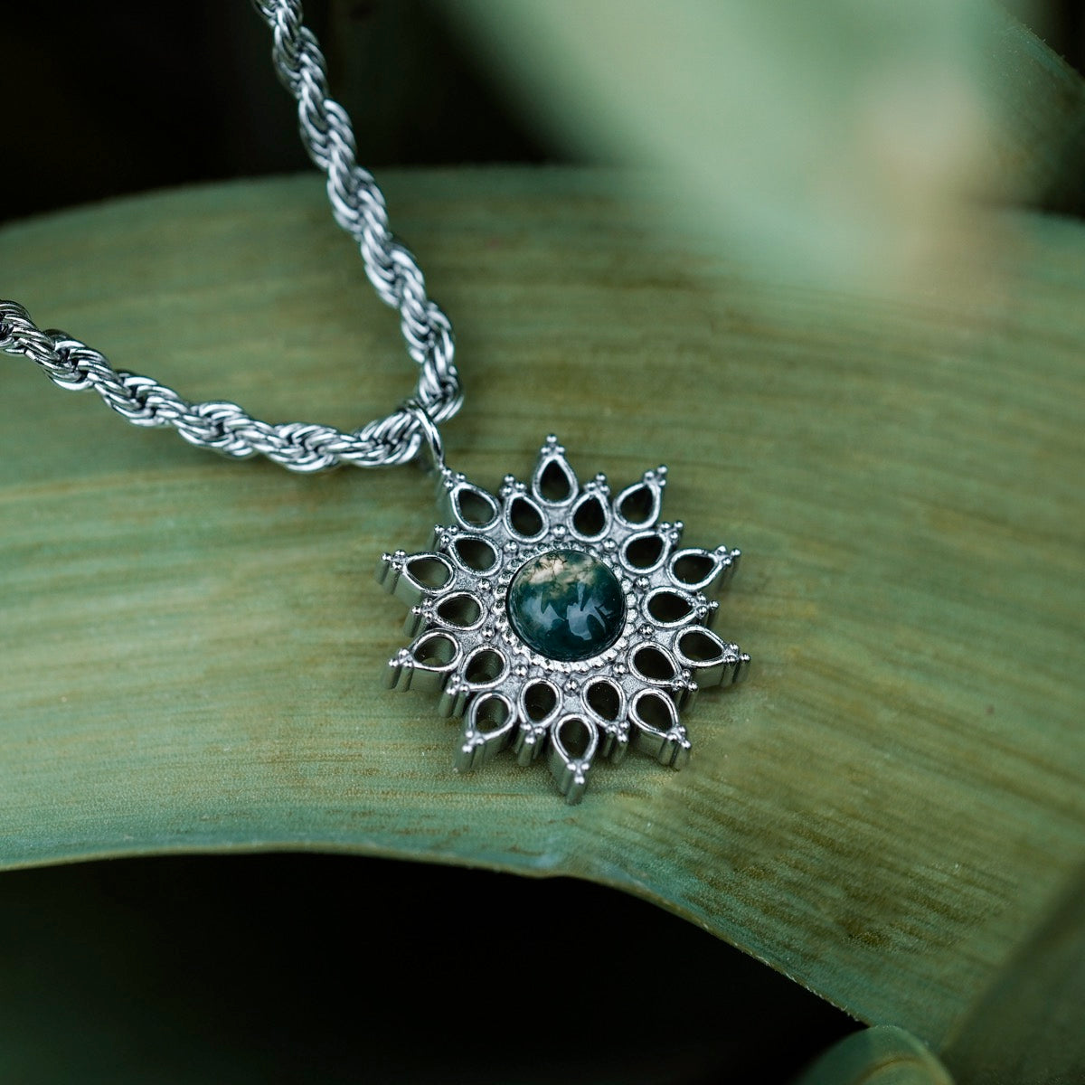 "Suncatcher Necklace" necklace showcasing a marble and silver design with intricate details.