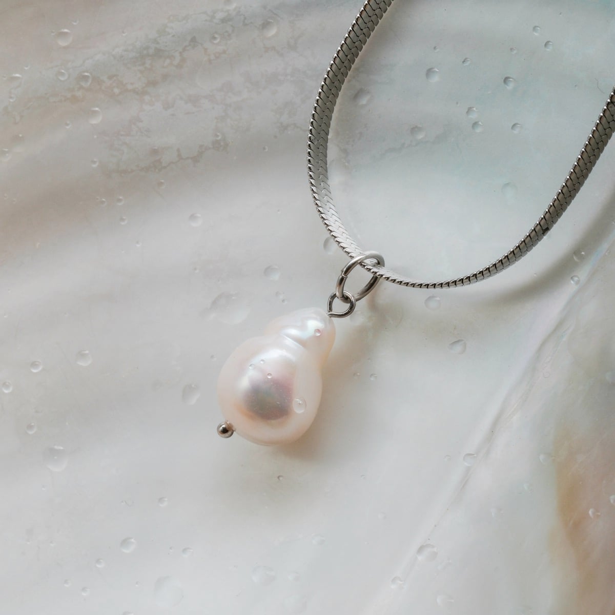 "Summersweet Necklace" necklace featuring a baroque pearl pendant on a sleek silver chain.