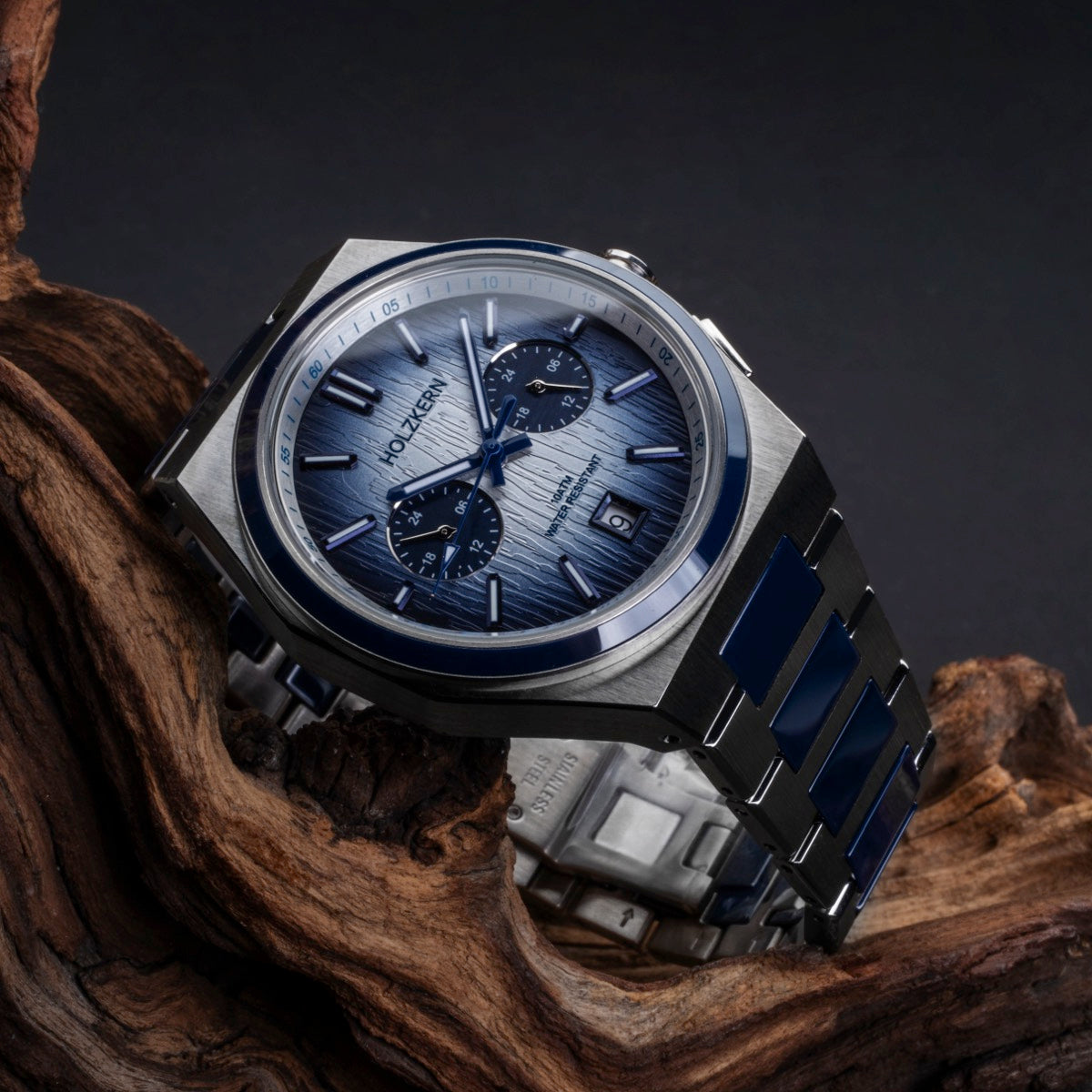 "Oceanswell" watch with a ceramic and silver build, featuring a sleek, modern design against a wooden background.