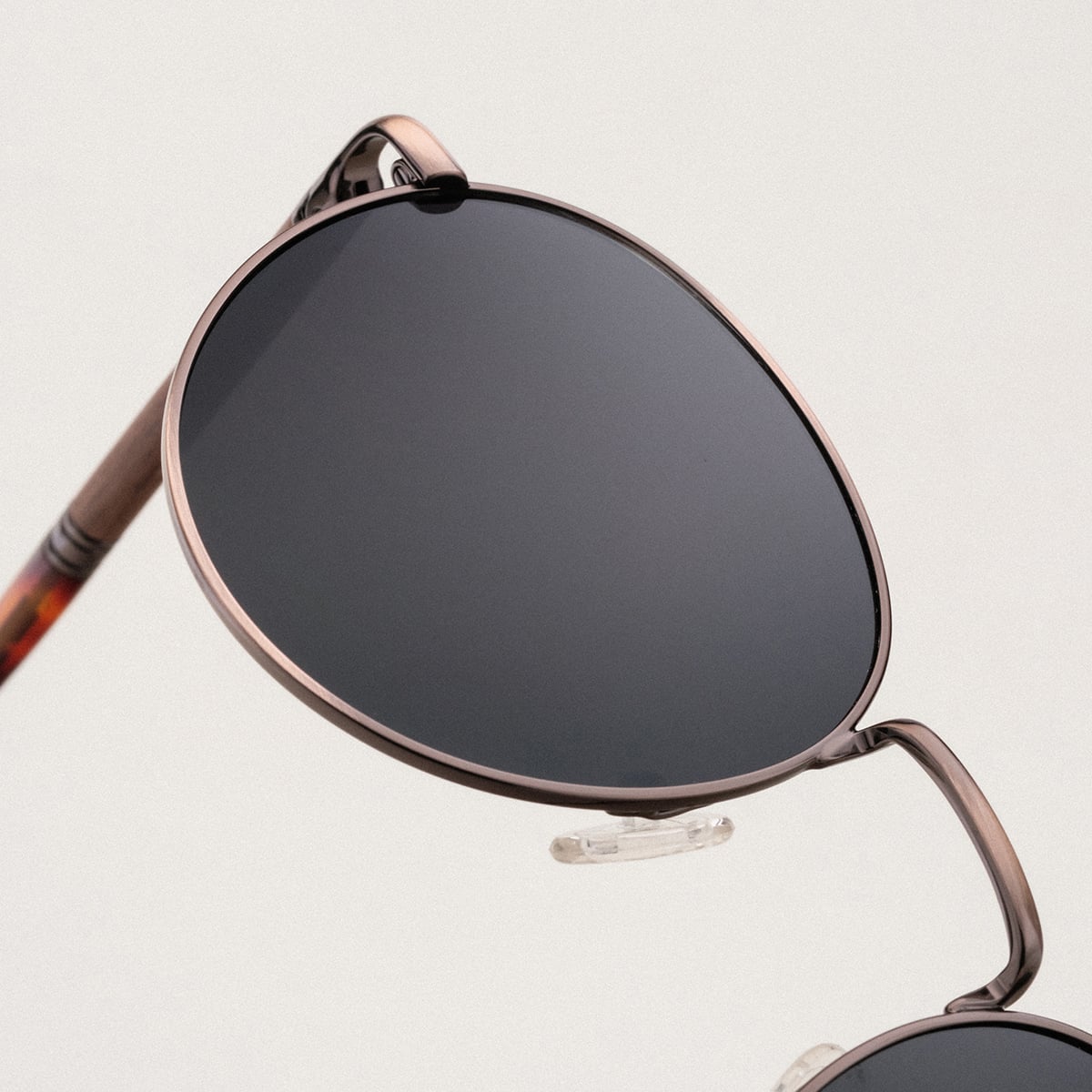 "The Achiever" sunglasses featuring a walnut and copper design with a sleek, modern style.