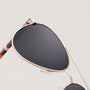"The Badass I" sunglasses feature a stylish walnut frame with matte gold accents.