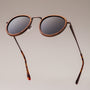 "The Loving" sunglasses featuring a zebrawood frame and antique copper accents in a stylish round design.