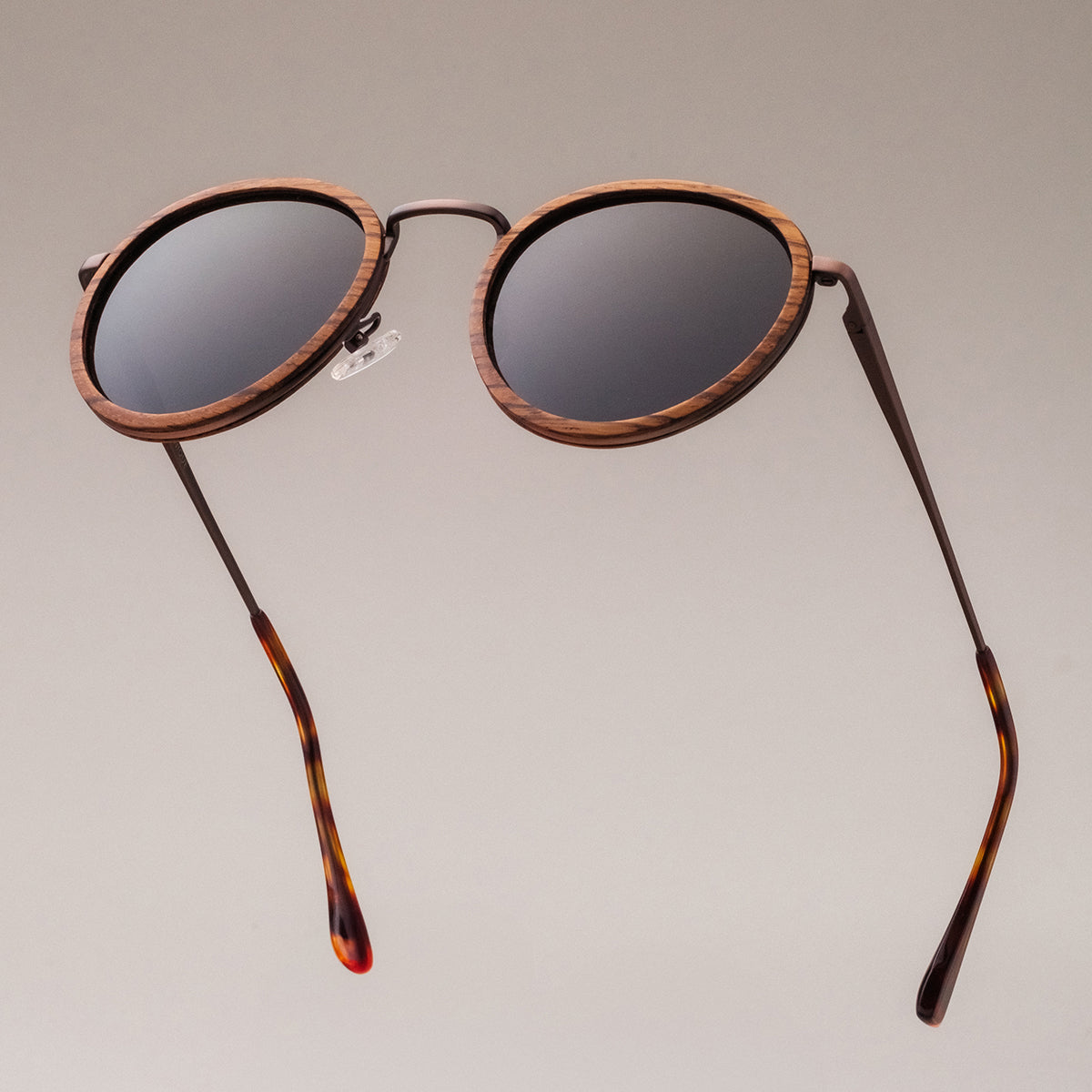 "The Loving" sunglasses featuring a zebrawood frame and antique copper accents in a stylish round design.