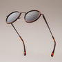 "The Radiant S" sunglasses feature a walnut and copper design with round lenses and tortoiseshell arms.