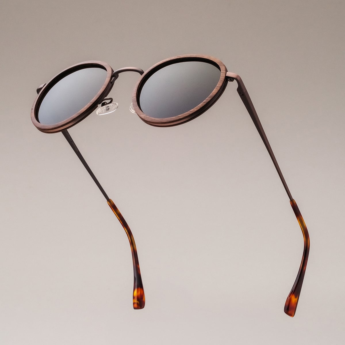"The Radiant S" sunglasses feature a walnut and copper design with round lenses and tortoiseshell arms.