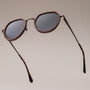 "The Wanderer", sunglasses with walnut frame and bronze accents, featuring a sleek design.