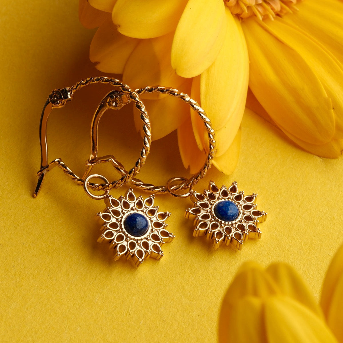 Suncatcher earrings: Elegant gold earrings with lapis lazuli accents and intricate, sun-inspired design.