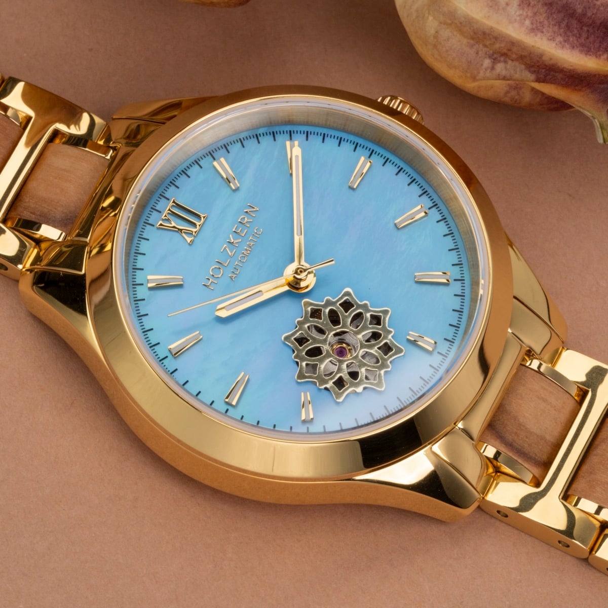 "Kaleidoscopic" watch featuring a nacre dial and olive accents with a gold finish.