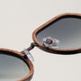"The Wanderer" sunglasses with walnut frames and bronze accents, featuring a sleek and stylish design.