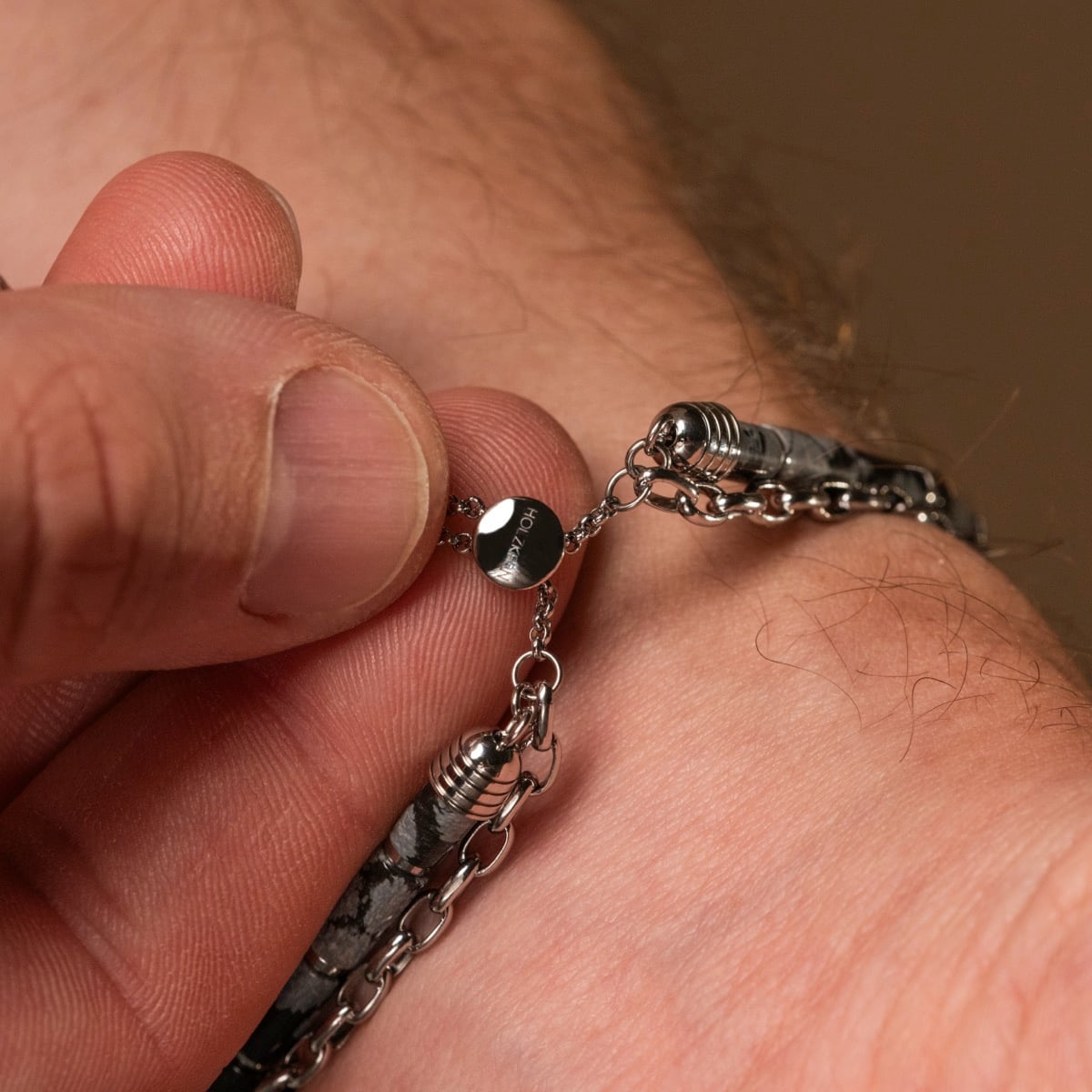 "Supersonic" bracelet featuring an obsidian and silver style with intricate chain design.