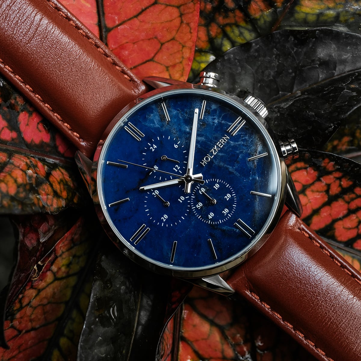 "Naturalist", elegant watch with a blue marble face and silver accents, complemented by a brown leather strap.