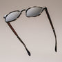 "The Comedian" sunglasses with a sleek Leadwood frame and Khaki Dust accents, offering a stylish, modern design.