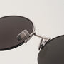 "The Adventurous" sunglasses featuring walnut and dark gray finishes with sleek, modern styling.