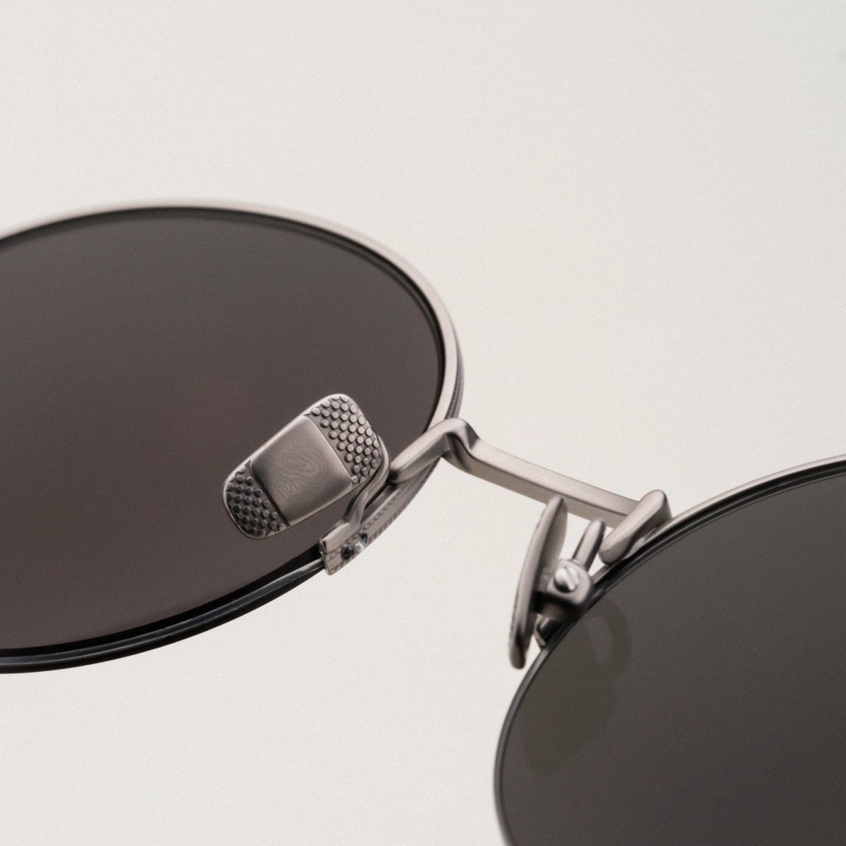 "The Adventurous" sunglasses featuring walnut and dark gray finishes with sleek, modern styling.
