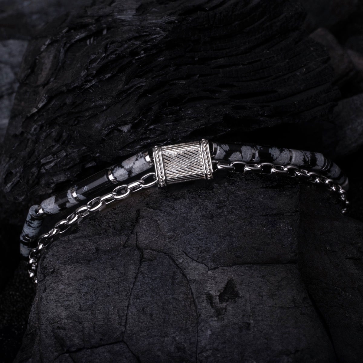 "Supersonic" bracelet featuring an obsidian and silver design with intricate detailing on a contrasting dark background.