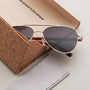 "The Badass I" sunglasses featuring walnut and matte gold accents in an elegant case.