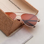 "The Badass II" sunglasses featuring a walnut and matte gold design with a sleek, modern aesthetic.