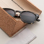 "The Comedian" sunglasses in Leadwood/Khaki Dust style, featuring a sleek, modern design with a unique cork case.
